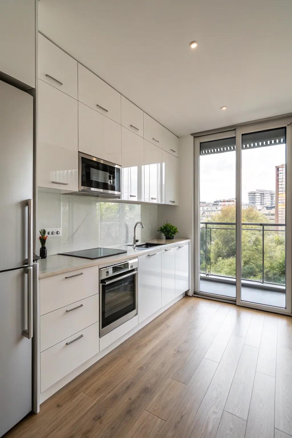 A minimalist one-wall kitchen featuring shimmering cabinets and stainless steel fixtures.