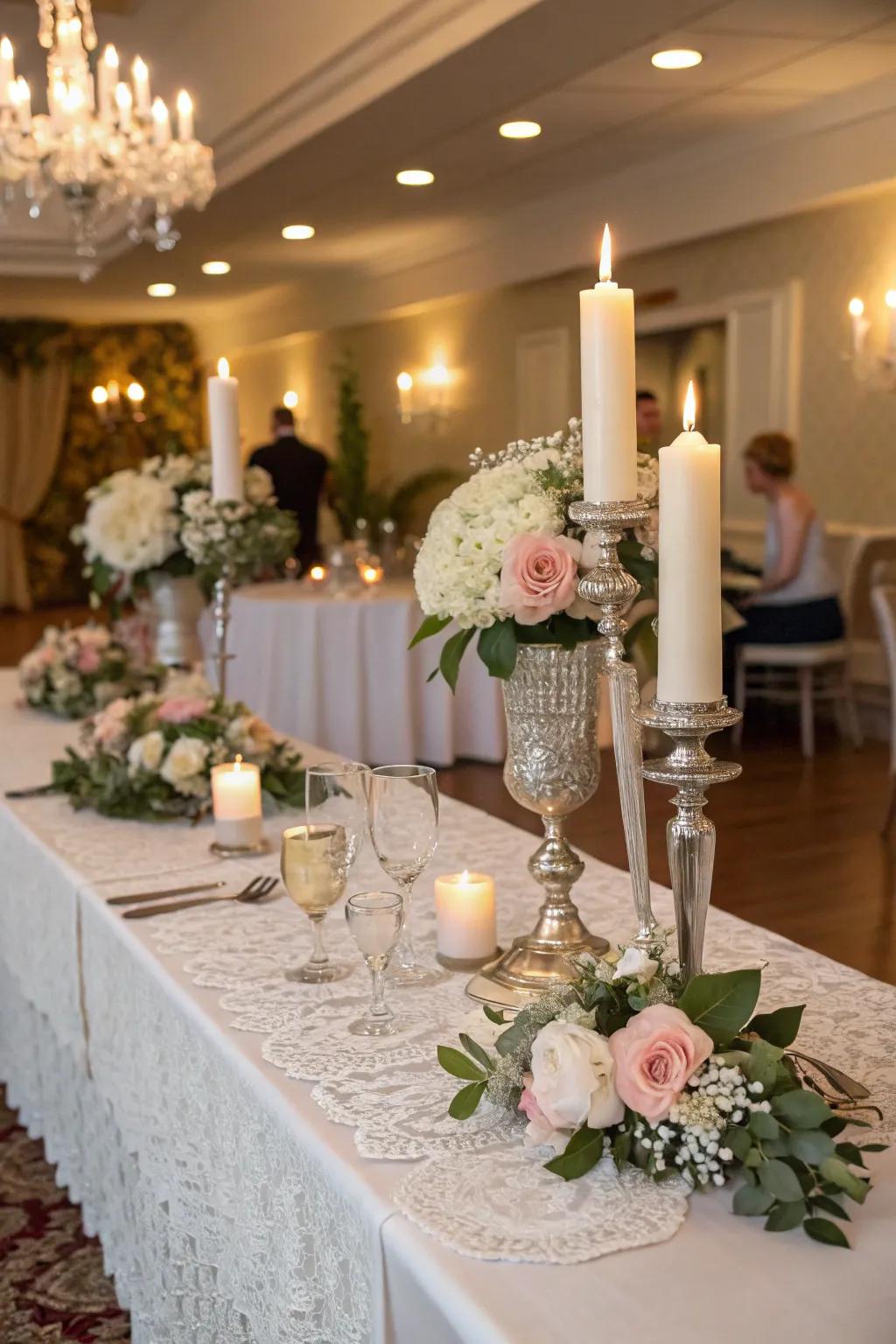 A bride and groom table featuring period light holders and delicate cloths.