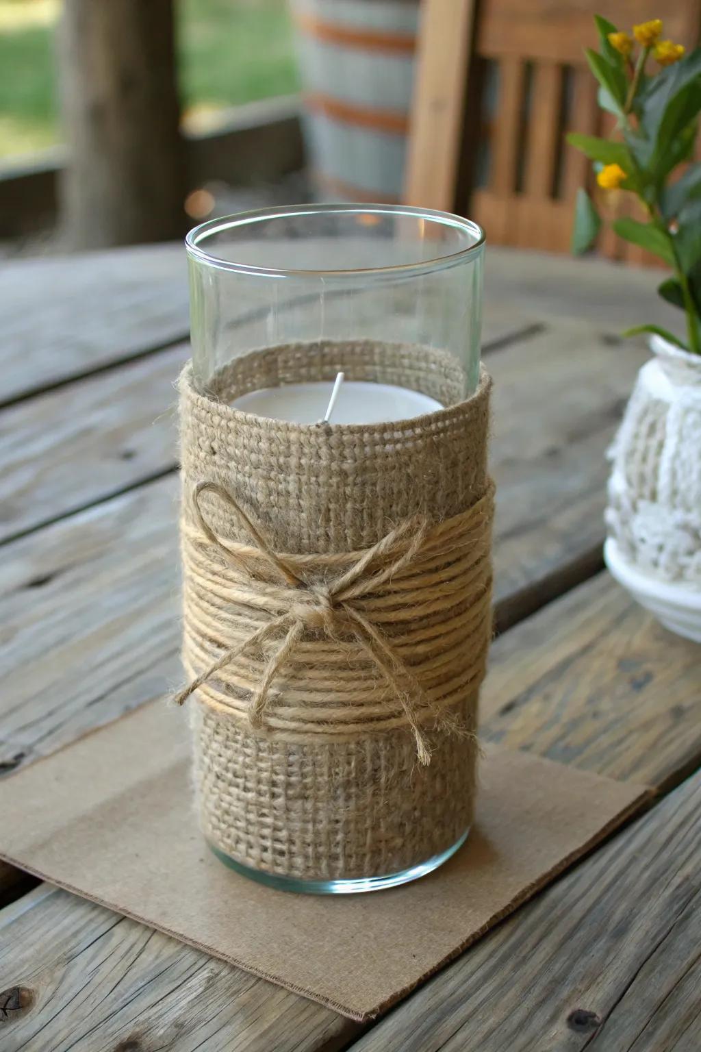 Twine and burlap enfolding a hurricane vase, contributing a trace of rustic allure.