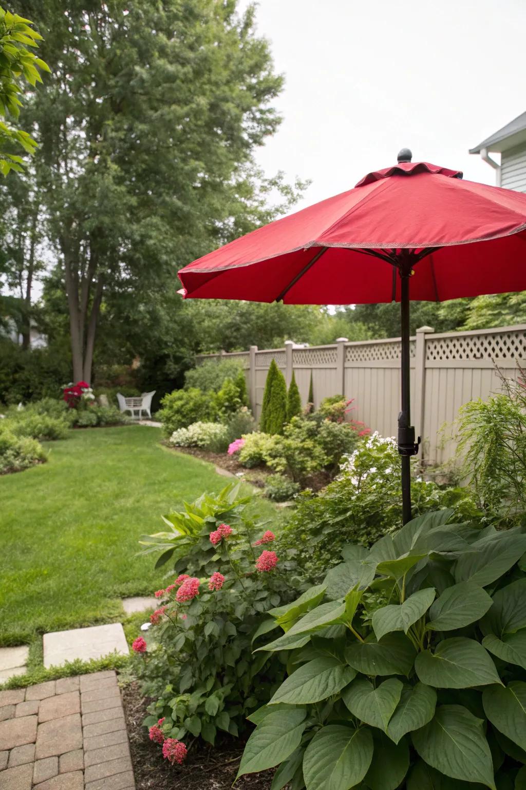 A backyard with a vibrant red umbrella for a pop of color.