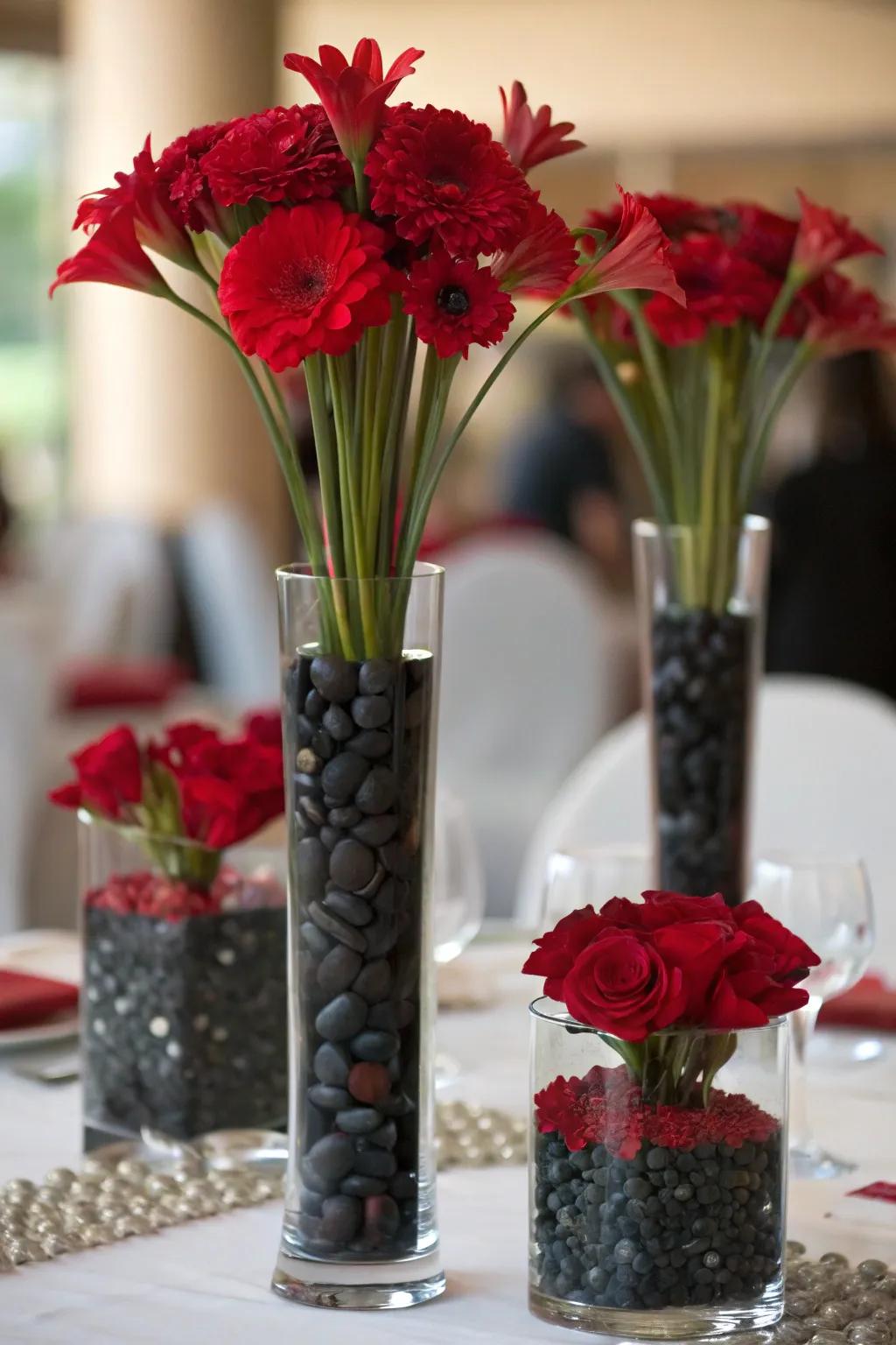 Receptacles of varying heights populated with scarlet flowers alongside dark stones built to transmit essence.