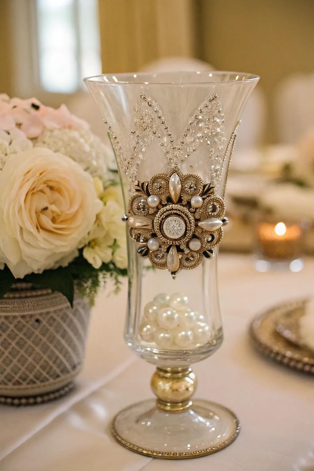An antique brooch encased inside a hurricane vase, which integrates a distinct vintage element.