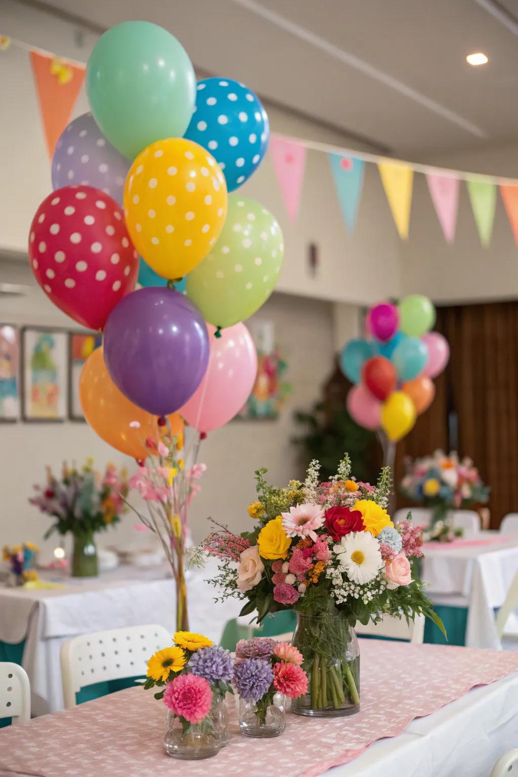 A celebratory table featuring balloon arrangements and coordinating floral centerpieces.