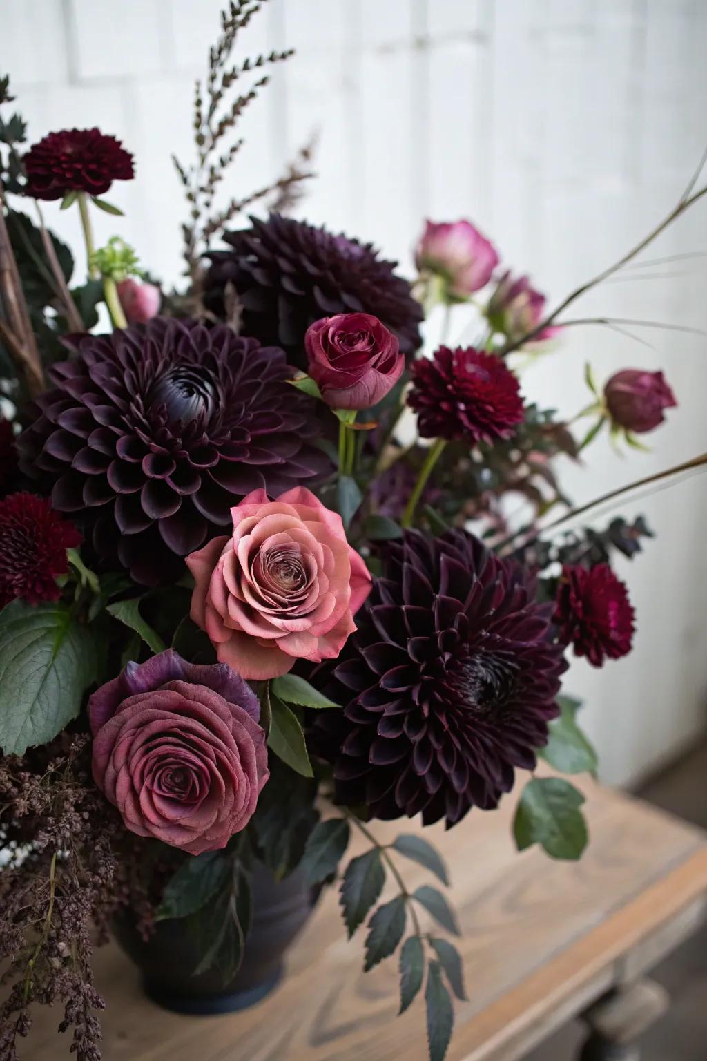 A brooding bouquet composed of shadowy dahlias and plum roses.