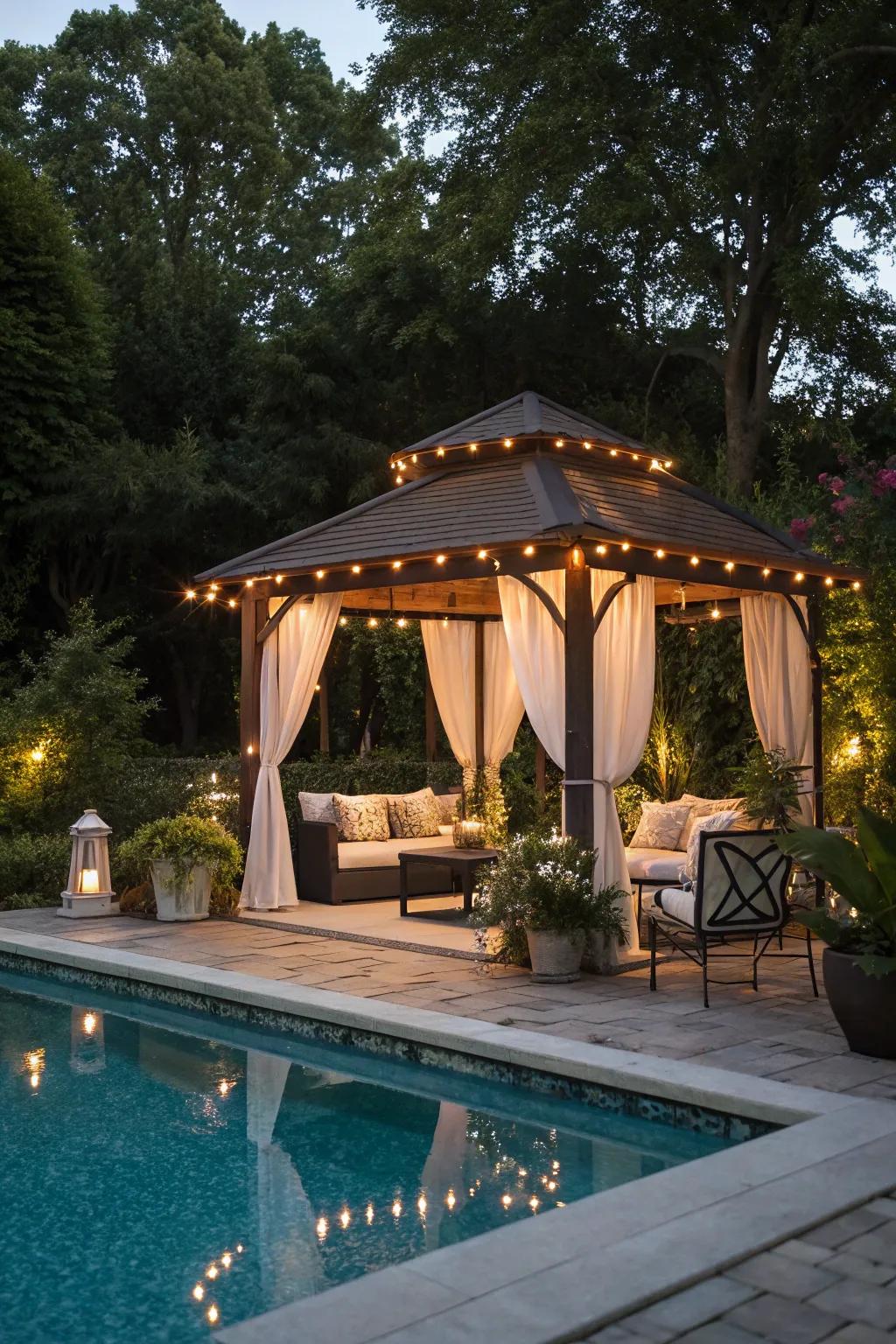Overhead lighting in a gazebo creates a cozy gathering spot by the pool.