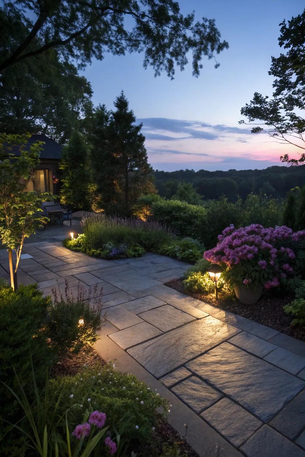 A slate patio beautifully lit with landscape lighting.